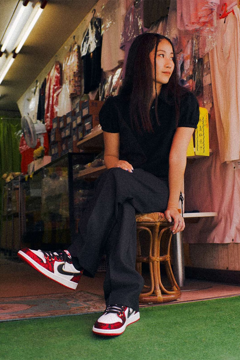 Mağaza önünde oturan kadının ayağında Air Jordan 1 Low