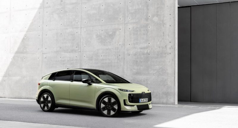 Audi A2 e-tron açık yeşil gövdesiyle beton bir binanın önünde