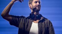 Kulaklığı boynunda, elini havaya kaldıran Calvin Harris