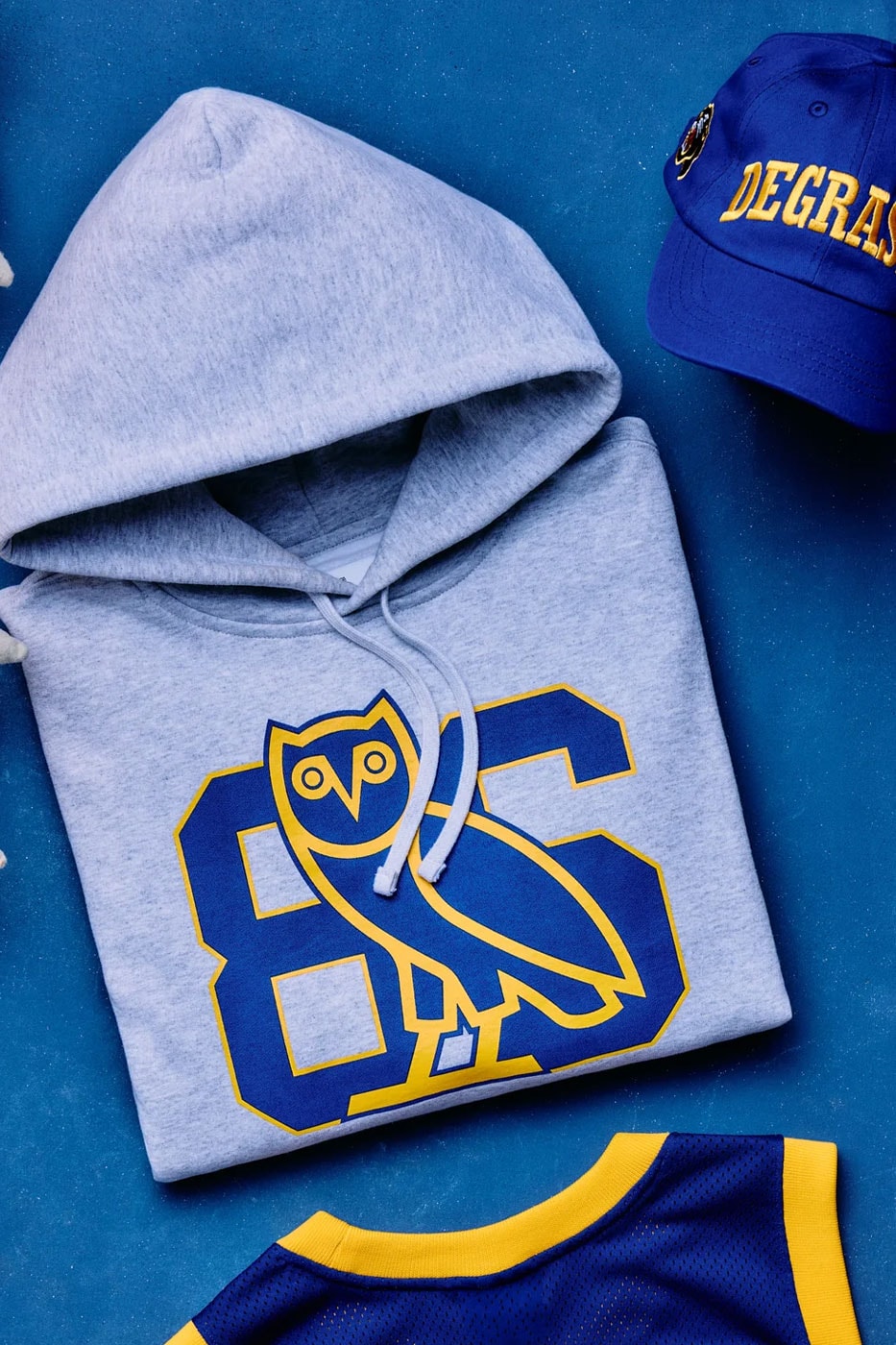Gri kapüşonlu sweatshirt üzerinde 86 ve baykuş logosu