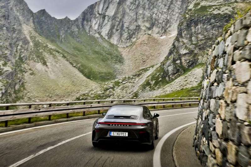Dağ yolunda viraj alan Porsche 911 GT3 Bergsport'un arkadan görünümü