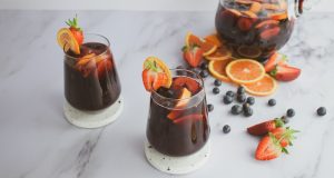 Sangria nasıl yapılır: mermer masada sürahi ve iki bardak meyveli sangria