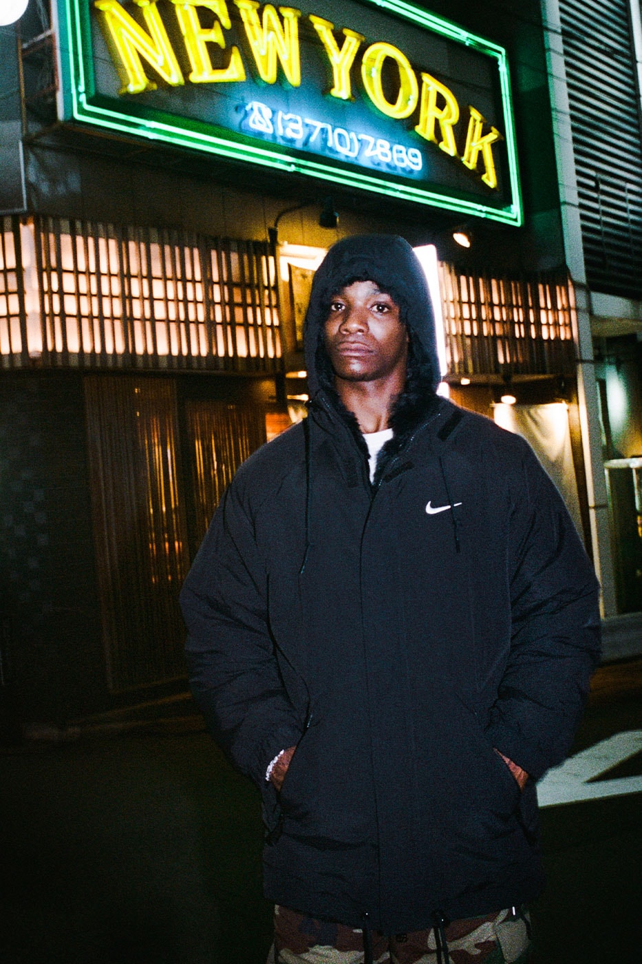 Supreme Nike siyah naylon parka, New York tabelasının önünde