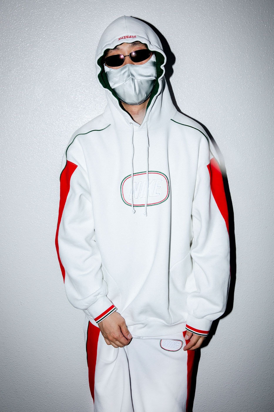 Supreme Nike beyaz kapüşonlu sweatshirt, kırmızı kol paneliyle