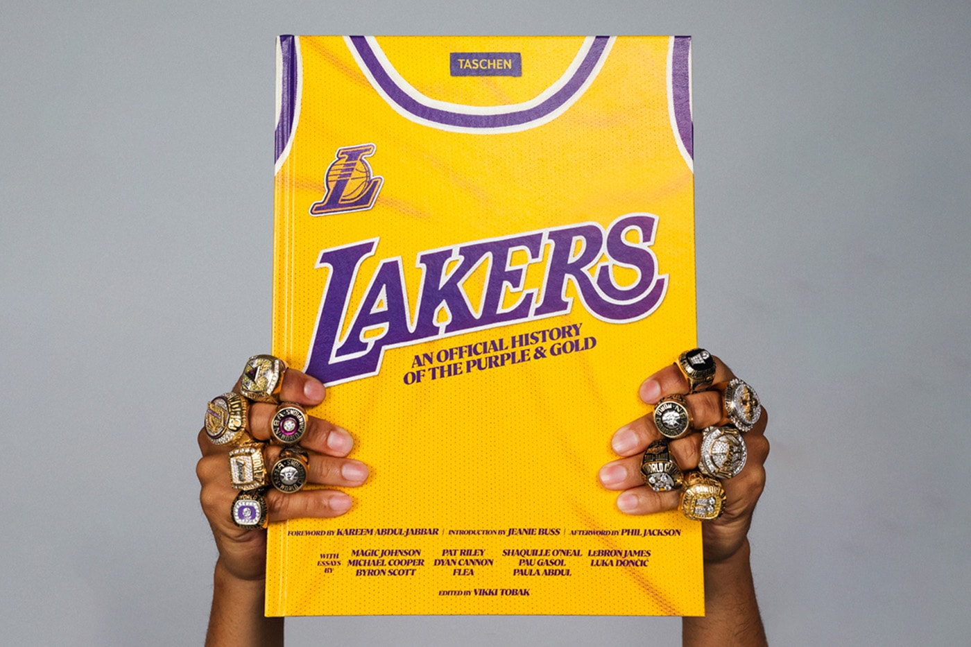 Şampiyonluk yüzükleri takılı ellerde TASCHEN Lakers kitabı
