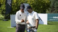 Alba golf turnuvasında beyaz polo tişörtlü iki oyuncu