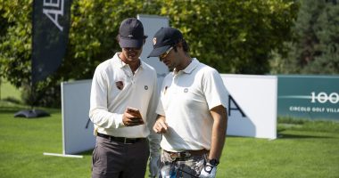 Alba golf turnuvasında beyaz polo tişörtlü iki oyuncu