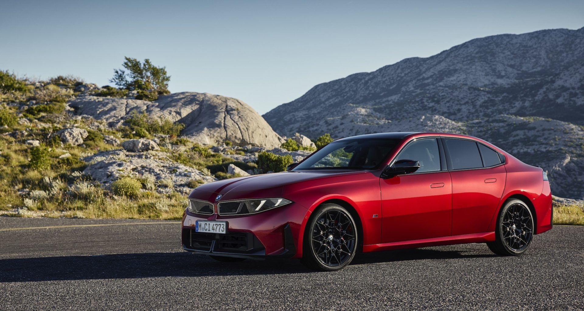 BMW 3 Serisi G50: kırmızı yeni nesil sedan kayalık bir manzara önünde