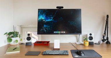 Çalışma masası setup: ahşap masada monitör, hoparlörler ve klavye