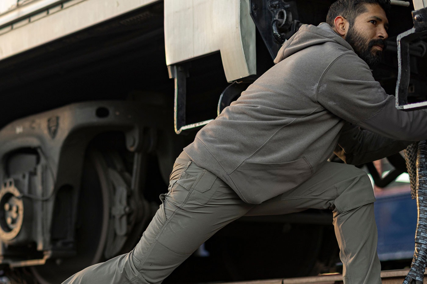 Gri Carhartt Steel Series kıyafetle kamyona çıkan işçi