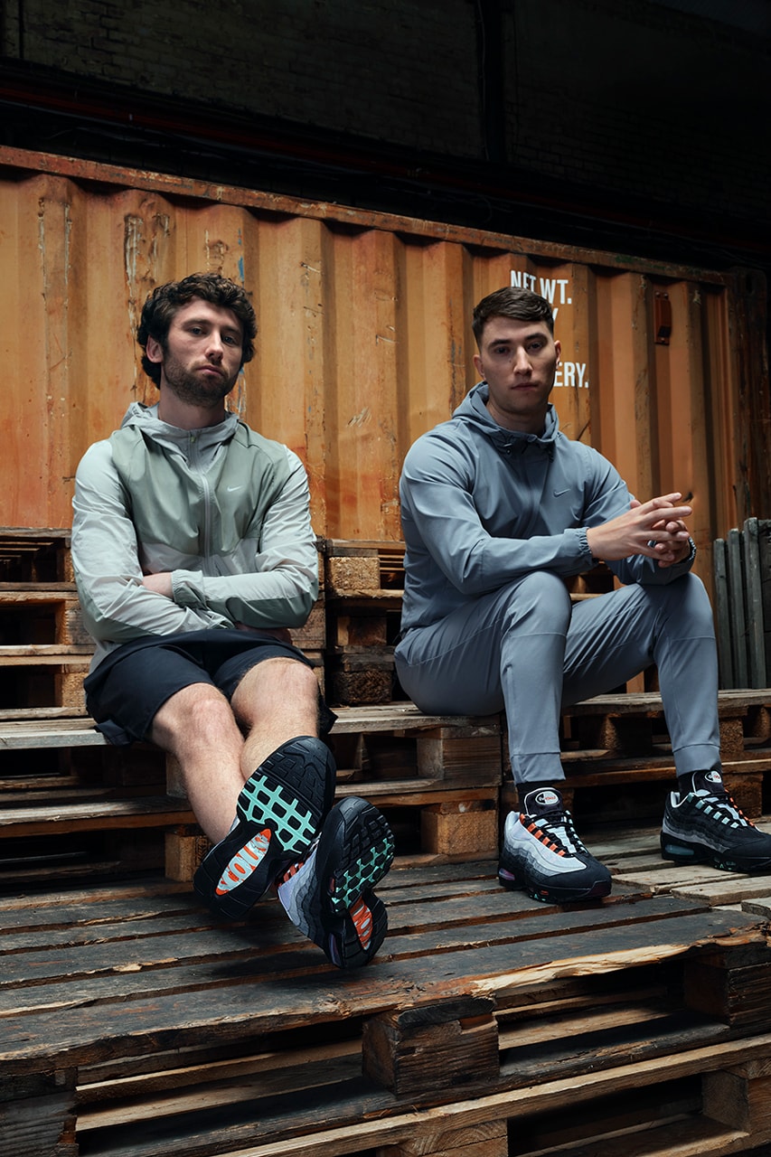 Air Max 95 Liverpool giyen iki kişi paletlerin üzerinde